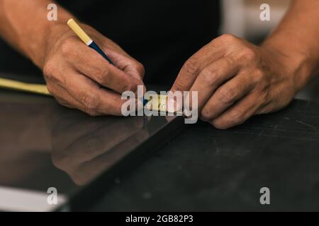 Man markiert eine Oberfläche mit einem Messgerät in einer Werkstatt Stockfoto