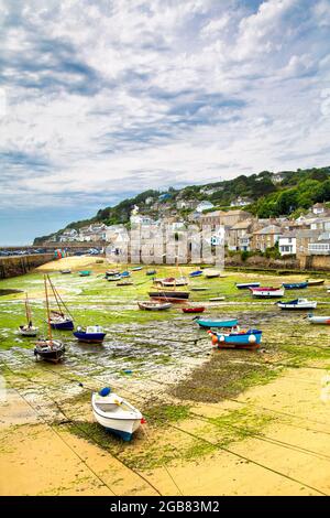 Boote, die bei Ebbe im Mousehole Harbour, Mousehole, Penwith Penwith Peninsula, Cornwall, Großbritannien, gestrandet sind Stockfoto