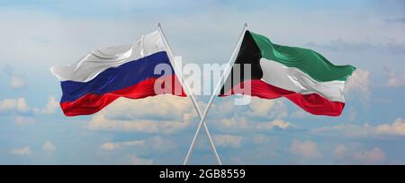 Flaggen von Russland und Kuwait winken im Wind auf Fahnenmasten gegen den Himmel mit Wolken am sonnigen Tag. Symbolisieren Beziehung, Dialog zwischen zwei Ländern Stockfoto