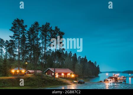 Schweden. Schweden. Wunderschönes Rotes Schwedisches Holzhütten-Haus An Der Rocky Island Küste In Der Sommernacht. See- Oder Flusslandschaft. Wunderschönes Holz Stockfoto