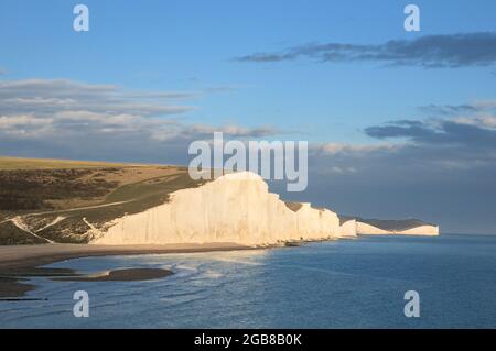 Die berühmten Kreidefelsen der Seven Sisters an der Südküste Englands, zwischen Seaford und Eastbourne, East Sussex, Großbritannien, werden am frühen Abend von Sonnenlicht durchflutet Stockfoto