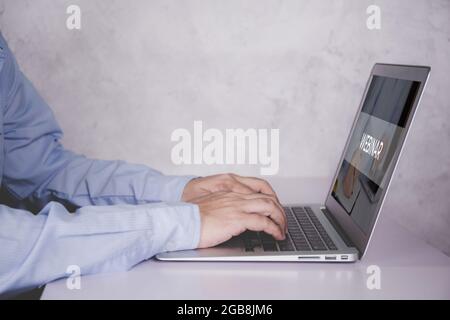 Hände des Mannes, der Laptop-Computer mit Webinar am Schreibtisch tippt, Videokonferenz, Bildung mit Online-E-Learning, Mann, der Notebook ansieht, um Dista zu lernen Stockfoto