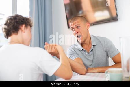 Vater und Sohn im Wettbewerb im Armdrücken Stockfoto