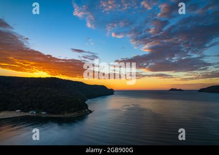 Fischerboote und Sonnenaufgang in Brisk Bay vom Patonga Beach an der Central Coast von NSW, Australien. Stockfoto