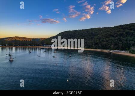 Fischerboote und Sonnenaufgang in Brisk Bay vom Patonga Beach an der Central Coast von NSW, Australien. Stockfoto