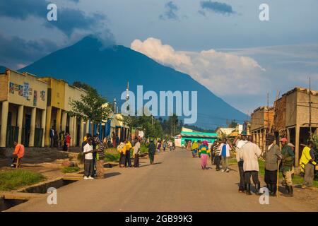 Kleines Dorf vor den aufragenden Vulkanen des Viruna-Nationalparks, Ruanda, Afrika Stockfoto