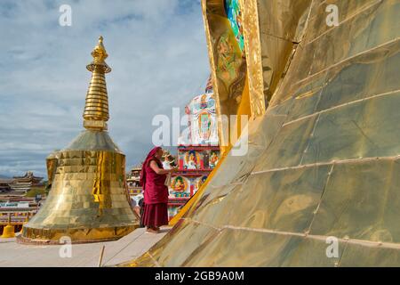 Tibetischer buddhistischer Mönch auf neuer großer, bemalter und vergoldeter Stupa, Stupa im Kloster Wutun Si, Tongren, Repkong, Qinghai, ehemals Amdo, Tibet, China Stockfoto