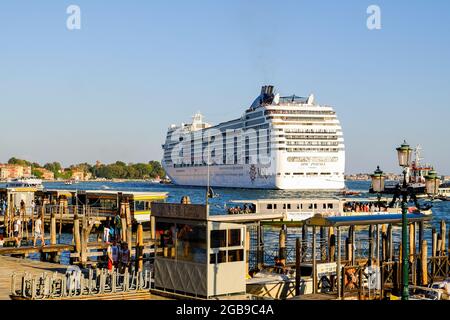 Venedig, Italien. September 2018. Der Linienschiff MSC Poesia fährt den Kanal vor dem Markusplatz hinauf.ab August 2021 dürfen große Kreuzschiffe nicht mehr in der Nähe des Markusplatzes und danach nicht mehr am Giudecca-Kanal vorbeifahren, laut den Behörden verschmutzen sie die Luft und das Wasser, Schäden am Meeresboden und Veränderungen des Ökosystems der Lagune Bisher war dies die Route durch das Herz Venedigs, die von allen Linienschiffen, die in die Lagune eindeifen, einnahm, um jährlich Millionen von Touristen abzuschütten.nach mehreren Monaten Unterbrechung, Die Riesen der Meere hatten bei der T wieder begonnen, Venedig zu durchqueren Stockfoto