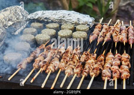 BBQ Burger, gegrillte Herzen auf Spieße und Rauch Grillparty. Nahaufnahme. Stockfoto
