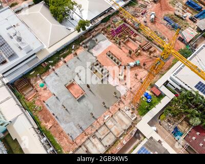 Luftaufnahme des Krans mit großem Bagger auf der Baustelle und Arbeiter Gießen eines nassen Beton auf der Baustelle, Betonbau Stockfoto