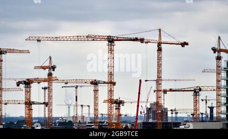Hamburg, 22. Juli 2021: Ensemble von Baukräne gegen den grauen Himmel der Großstadt Stockfoto