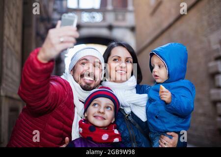 Familie mit Kindern, die durch die Stadt spazieren und Selfie machen Stockfoto