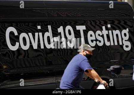 New York, USA. August 2021. Ein Radfahrer fährt an einem mobilen COVID-19-Testgelände in New York City, USA, vorbei, 2. August 2021. Der Bürgermeister von New York, Bill de Blasio, empfahl am Montag allen dringend, eine Maske in Innenräumen zu tragen, nachdem die COVID-19-Infektionen in der ganzen Stadt stark anstiegen. Quelle: Wang Ying/Xinhua/Alamy Live News Stockfoto