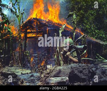 MY THO, VIETNAM - 05. April 1968 - My Tho, Vietnam. Ein Viet Cong Basislager wird verbrannt. Im Vordergrund ist der private First Class Raymond Rumpa aus St. Stockfoto