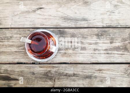 Ein Glas Tee isoliert auf einem Tisch aus natürlichem braunem Hartholz. Strukturiertes Hintergrundbild. Hochwertige Fotos Stockfoto