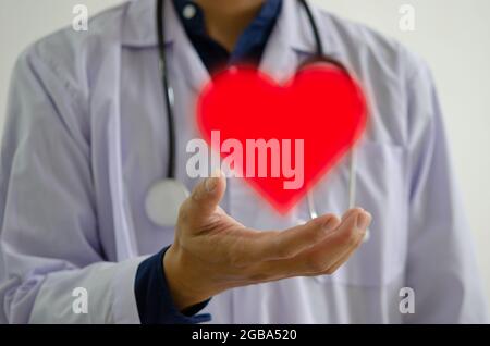 Arzthand mit dem roten Herzsymbol. Unterstützung von Ärzten, Krankenschwestern und medizinischem Personal Stockfoto