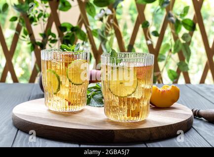 Sommermocktail oder Eistee aus Pfirsich, Limette und Minze Stockfoto