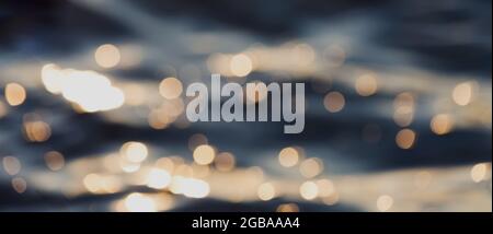 Wasserwellen mit goldenem Bokeh. Natürlicher abstrakter Wasserhintergrund mit unscharfem Fokus. Banner. Stockfoto