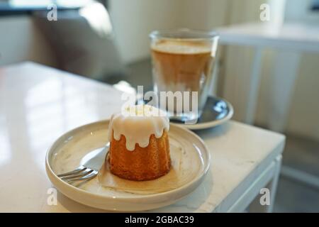 Zitronenkuchen mit einem Glas Latte-Kaffee serviert Stockfoto