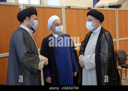 Teheran, Teheran, Iran. August 2021. Ein Handout-Bild, das vom Obersten Führer des Iran zur Verfügung gestellt wurde, zeigt den neuen iranischen Präsidenten EBRAHIM RAISI (R) zusammen mit dem ehemaligen iranischen Präsidenten HASSAN ROUHANI (C) während der Einweihungszeremonie von Raisi am 03. August 2021 in Teheran, Iran. Die iranischen Präsidenten werden zuerst vom obersten Führer, der laut Verfassung der eigentliche Staatschef ist, gebilligt und dann vor dem parlament den Eid ablegen. Ebrahim Raisi wurde am 03. August 2021 als neuer Präsident der Islamischen Republik Iran eingeweiht, da das Land mit der Wirtschaftskrise konfrontiert ist Stockfoto