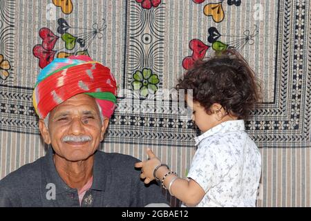 Nahaufnahme eines asiatischen Enkels liebt seinen Großvater und seinen Großvater, der traditionellen Turban auf dem Kopf trägt Stockfoto