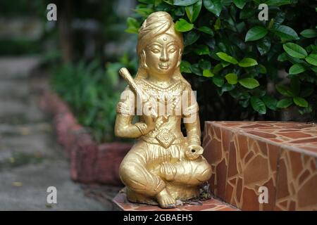 Eine kleine Tonfigur einer sitzenden Frau in einem buddhistischen Tempel Stockfoto