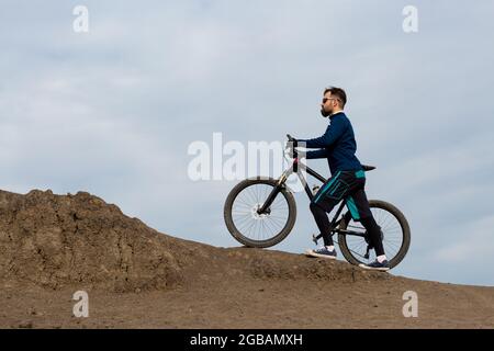 Bärtiger Bergradfahrer reitet Berge Stockfoto