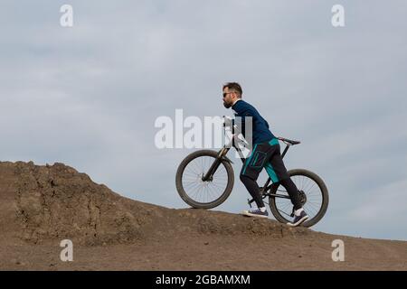 Bärtiger Bergradfahrer reitet Berge Stockfoto