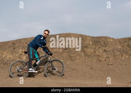 Bärtiger Bergradfahrer reitet Berge Stockfoto