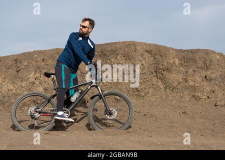 Bärtiger Bergradfahrer reitet Berge Stockfoto