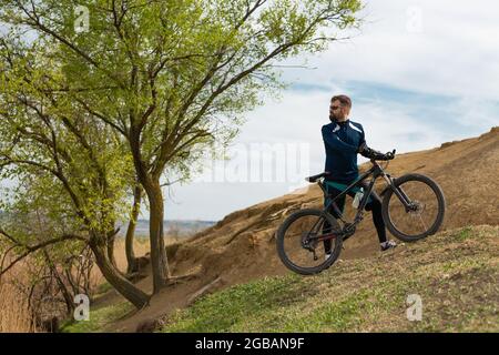 Bärtiger Bergradfahrer reitet Berge und Wald Stockfoto