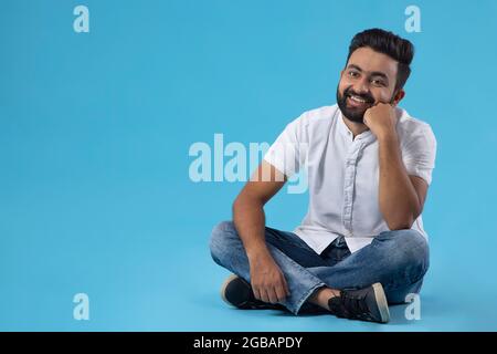 EIN GLÜCKLICHER BÄRTIGER MANN POSIERT VOR DER KAMERA Stockfoto