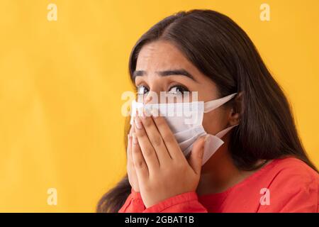 Porträt einer jungen, überraschten Frau mit Maske im Gesicht Stockfoto