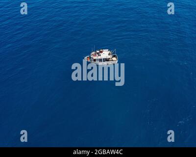 Luftaufnahme eines Fischereischiffs im blauen Meer vor der Küste Kalabriens, Italien Stockfoto