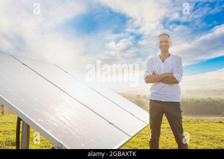 Der Ingenieur von oung überprüft den Betrieb der Sonne und die Sauberkeit der Photovoltaik-Solarzellen bei Sonnenuntergang. Konzept: Erneuerbare Energien, Technologie Stockfoto