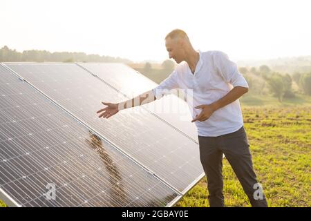 Der Ingenieur von oung überprüft den Betrieb der Sonne und die Sauberkeit der Photovoltaik-Solarzellen bei Sonnenuntergang. Konzept: Erneuerbare Energien, Technologie Stockfoto