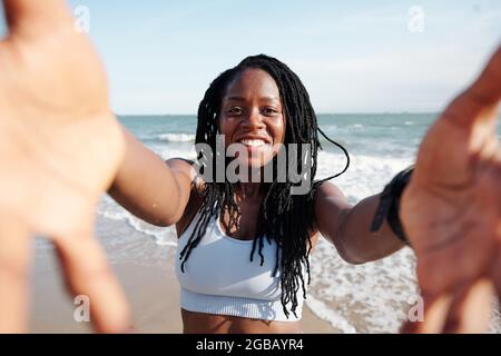 Glückliche, hübsche junge Frau, die gerne am Strand dreht oder Selfies macht Stockfoto