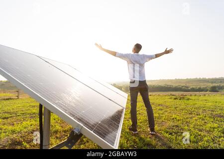 Der Ingenieur von oung überprüft den Betrieb der Sonne und die Sauberkeit der Photovoltaik-Solarzellen bei Sonnenuntergang. Konzept: Erneuerbare Energien, Technologie Stockfoto