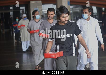 Lahore, Pakistan. August 2021. 28 Pakistaner, die aus dem Gefängnis Saudi-Arabiens entlassen wurden, haben am Flughafen Allama Iqbal in Lahore angekommen. Die Regierung zahlte für die Reise von 19 Passagieren. Sie kamen am Dienstagmorgen mit PIA-Flug 9248 am Allama Iqbal Airport an. Ihre Covid-19-Tests werden durchgeführt und dürfen nach der Überprüfung wieder verlassen werden. Farrukh Habib und Ijaz Chaudhry von PTI begrüßten sie. Sie sagten, dass zuvor 62 Pakistaner zurückgebracht wurden. (Foto von Rana Sajid Hussain/Pacific Press/Sipa USA) Quelle: SIPA USA/Alamy Live News Stockfoto