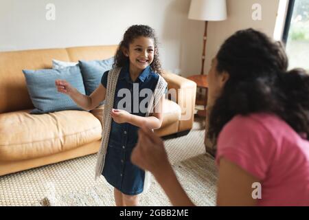Glückliche Mischrasse Mutter und Tochter tanzen im Wohnzimmer Stockfoto