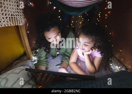 Glückliche gemischte Rasse Mutter und Tochter mit Laptop in provisorisch Zelt Stockfoto