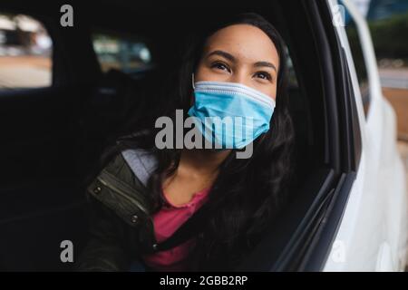 Asiatische Frau trägt Gesichtsmaske sitzt im Taxi Stockfoto