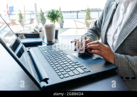 Womans Hände tippen in Notizbuch im Café. Fenster im Hintergrund. Stockfoto