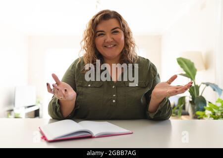 Porträt einer kaukasischen Frau, die einen Videoanruf führt, spricht und lächelt Stockfoto