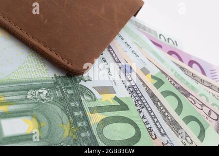 Brieftasche mit Euro und Dollar ragen aus ihm heraus, isoliert Stockfoto