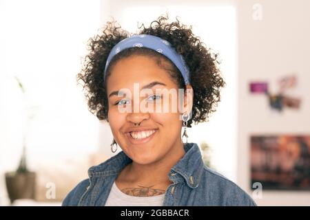 Hübsche weibliche Teenager in Casualwear, die Sie mit toothy Lächeln anschaut Stockfoto