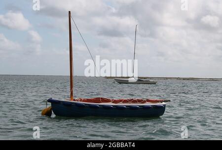 Zwei kleine Segelboote, die in einem Küstenhafen festgemacht sind. Stockfoto