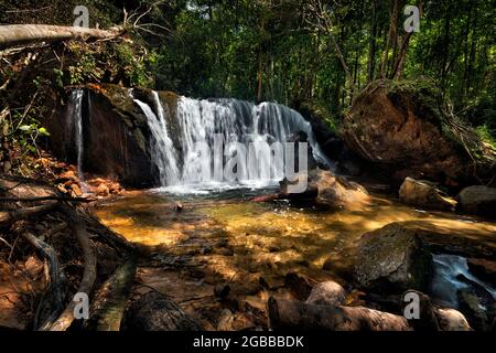 Ein großer Wasserfall in einem Wald mit Sonnenlicht Stockfoto