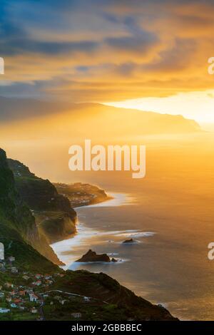 Brennender Himmel bei Sonnenuntergang über den Dörfern Arco de Sao Jorge und Ponta Delgada am Meer, auf der Insel Madeira, Portugal, Atlantik, Europa Stockfoto