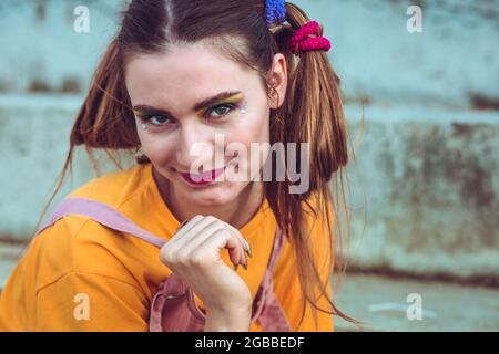 Porträt eines jungen, blonden Mädchens mit Zöpfen. Starke Make-up Stockfoto